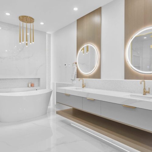 gold towel warmer, in-floor heating with a bench, and a hex tile-lined wall niche.